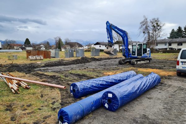 Baufeld mit Bagger und Bauzäunen