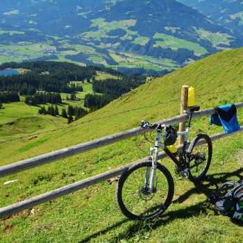 Fahrrad lehnt an Zaun auf der hohen Salve im Hintergrund Blick über das Tal