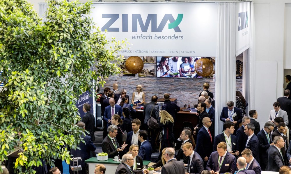 Aufnahme von oben auf Messebesucher vor dem ZIMA Stand bei der Expo Real 2019