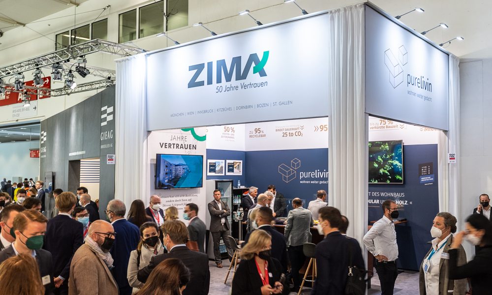 Messebesucher in der Messehalle der EXPO Real in München, ZIMA und purelivin-Stand im Fokus